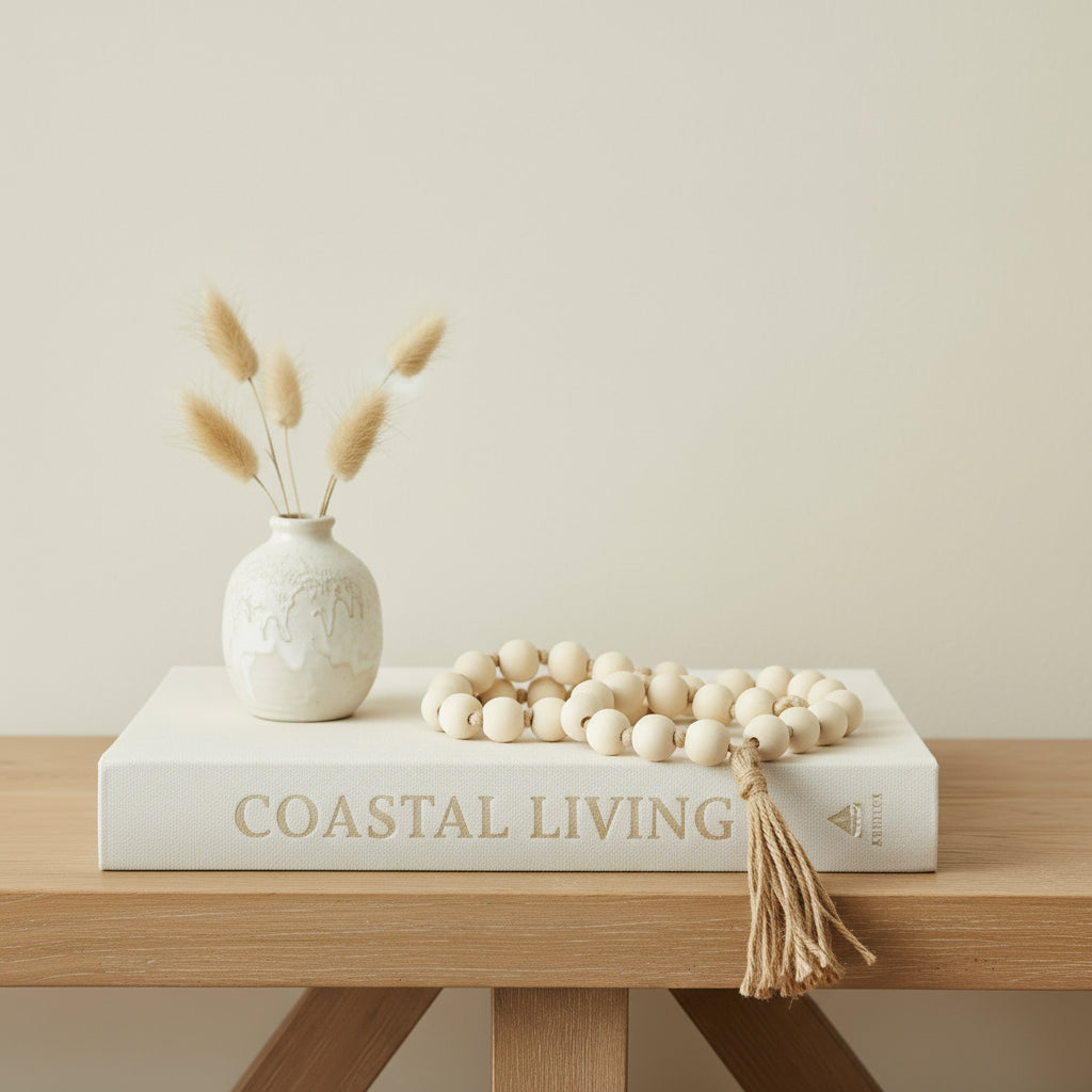 Wooden handmade bead tassel draped over a coastal book in a beach house console
