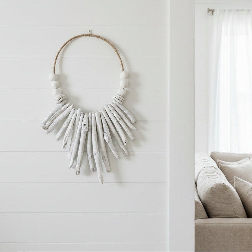 A bohemian-style wall hanging necklace made from natural driftwood and hand rolled clay beads