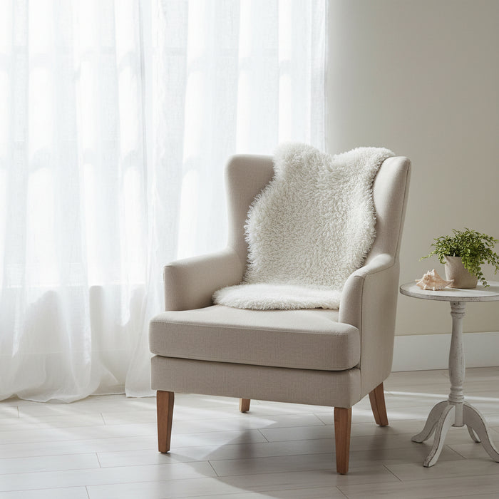Beige armchair with a white faux pelt fur throw beach house hamptons coastal decor