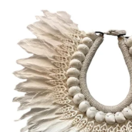 Decorative necklace with feather-like elements on a stand against a white background