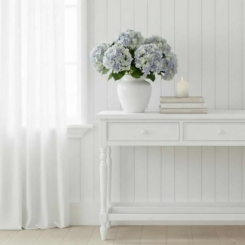 Add timeless elegance with our Faux Blue Hydrangea Stem featuring multi tonal, softly blended blue, ivory, and green petals. Perfect for coastal, Hamptons, and modern home styling.