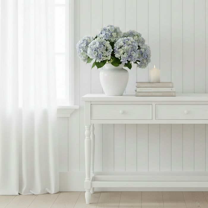 Add timeless elegance with our Faux Blue Hydrangea Stem featuring multi tonal, softly blended blue, ivory, and green petals. Perfect for coastal, Hamptons, and modern home styling.