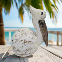 Wooden pelican figurine with a white distressed finish on a white background