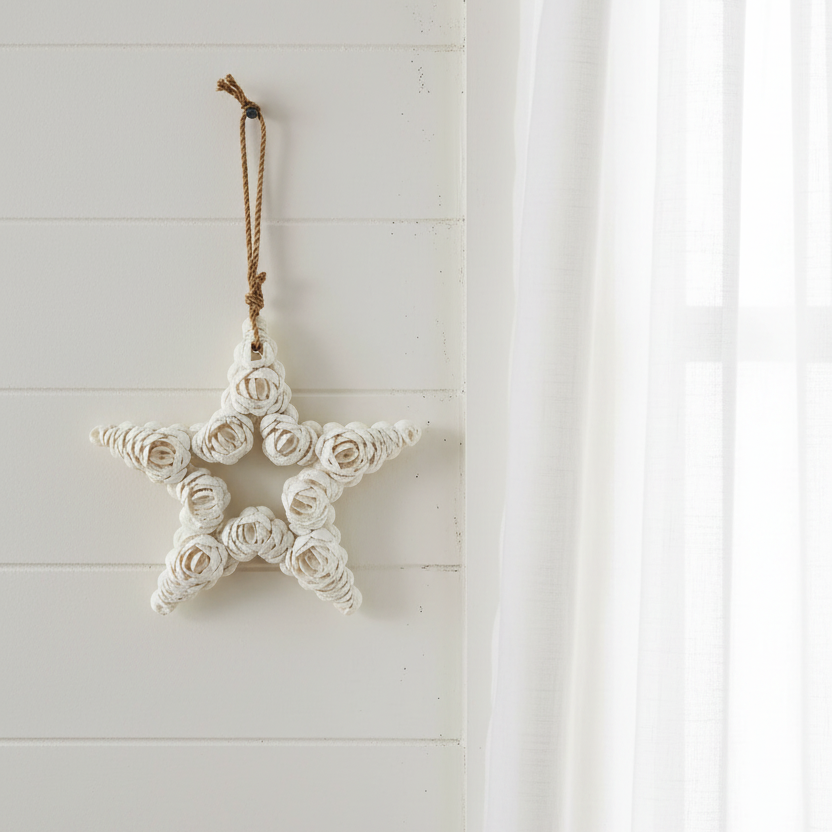 A handmade balinese white shell star-shaped hanging ornament with a brown cord loop at the top coastal home decor