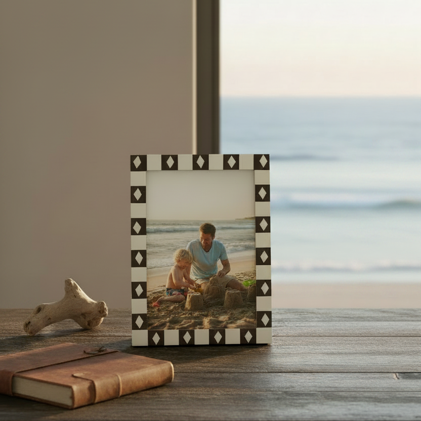 A rectangular picture frame with a cream and dark brown checkered border featuring repeating diamond motifs. 